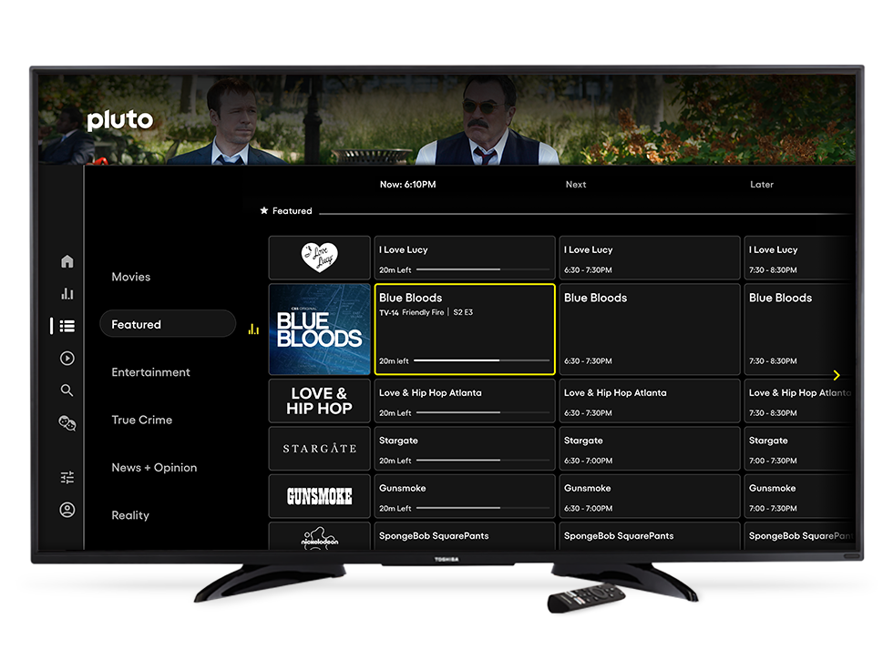Imagem promocional da grade da Pluto TV exibida em uma televisão