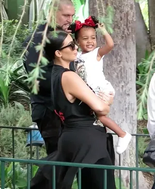 Happy Baby - North West is absolutely delighted with her sparkly Minnie Mouse ears as mom Kim Kardashian carries her around Disneyland.&nbsp;(Photo: Fern / Splash News)