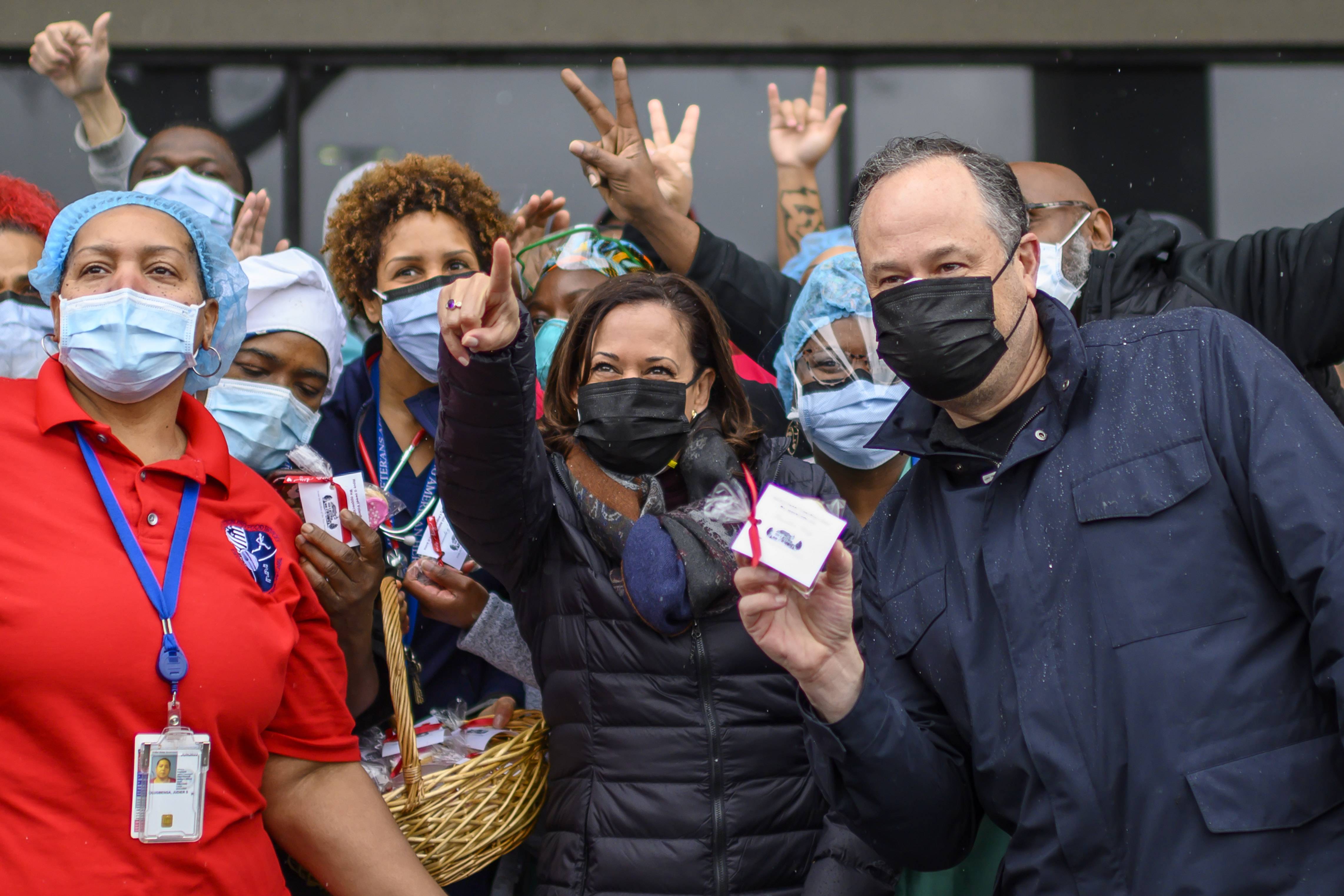 US Vice President Kamala Harris (C) and her husband,  Second Gentleman Doug Emhoff  (R), pose for a picture with healthcare workers at the Washington, DC, VA Center, a veterans hospital, as they delivered baskets of Valentine's cookies on February 13, 2021. (Photo by Eric BARADAT / AFP) (Photo by ERIC BARADAT/AFP via Getty Images)