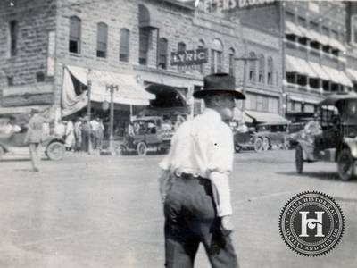Street Scene - A white man looks around an intersection during the 1921 Tulsa Race Massacre. Blacks were targeted during the violence, forcing many to flee their communities and hide from their assailants.&nbsp;