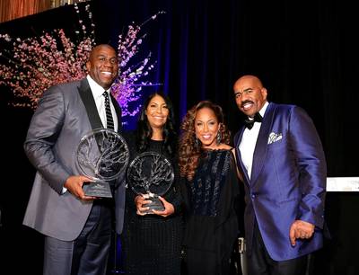 Black Excellence - Earvin &quot;Magic&quot; Johnson and his wife, Cookie, accept awards from Steve Harvey&nbsp;and his wife, Marjorie, on stage at the 2014 Steve and Marjorie Harvey Foundation Gala presented by Coca-Cola at the Hilton Chicago. (Photo: Neilson Barnard/Getty Images)