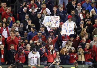 Fans Celebrate - Fans remained in the stands and witnessed the history-making win that generations of Red Sox fans have never been able to see. The last time they won a World Series in Fenway Park was September 1918. (Photo: AP Photo/Charlie Riedel)