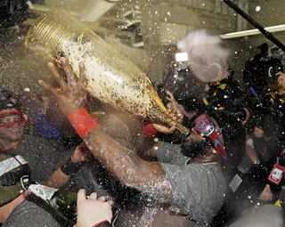 Popping Champagne  - Boston Red Sox MVP David Ortiz and his teammates put on goggles and opened large bottles of champagne to celebrate their win in the dug house. (Photo: AP Photo/David J. Phillip)