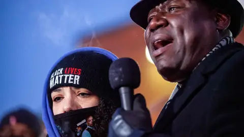 Attorney Ben Crump addresses the crowd next to Andre Hills daughter, Karissa Hill, at a press conference and candlelight vigil for Andre Hill outside the Brentnell Community Recreation Center in Columbus, Ohio on December 26, 2020. - The fatal shooting of an unarmed Black man by police in  Columbus, Ohio -- the US city's second such killing this month -- sparked a fresh wave of protests on December 24 against racial injustice and police brutality in the country. Andre Maurice Hill, 47, was in the garage of a house on the night of December 21 when he was shot several times by a police officer who had been called to the scene for a minor incident. (Photo by STEPHEN ZENNER / AFP) (Photo by STEPHEN ZENNER/AFP via Getty Images)