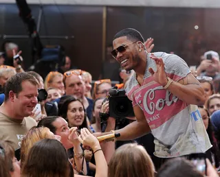 Sing-a-Long&nbsp; - Nelly passes his mic to a fan during his performance on NBC's Today show Labor Day concert in New York City. (Photo: Ilya S. Savenok/Getty Images)
