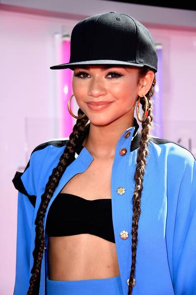 2014: Zendaya - Zendaya&nbsp;knows how to change up her look with the utmost finesse. Opting for sporty attire, the actress was red-carpet ready with her Letterman jacket, high-waisted skirt, and long braids placed neatly under a baseball cap. (Photo by Frazer Harrison/BET/Getty Images for BET) (Photo by Frazer Harrison/BET/Getty Images for BET)