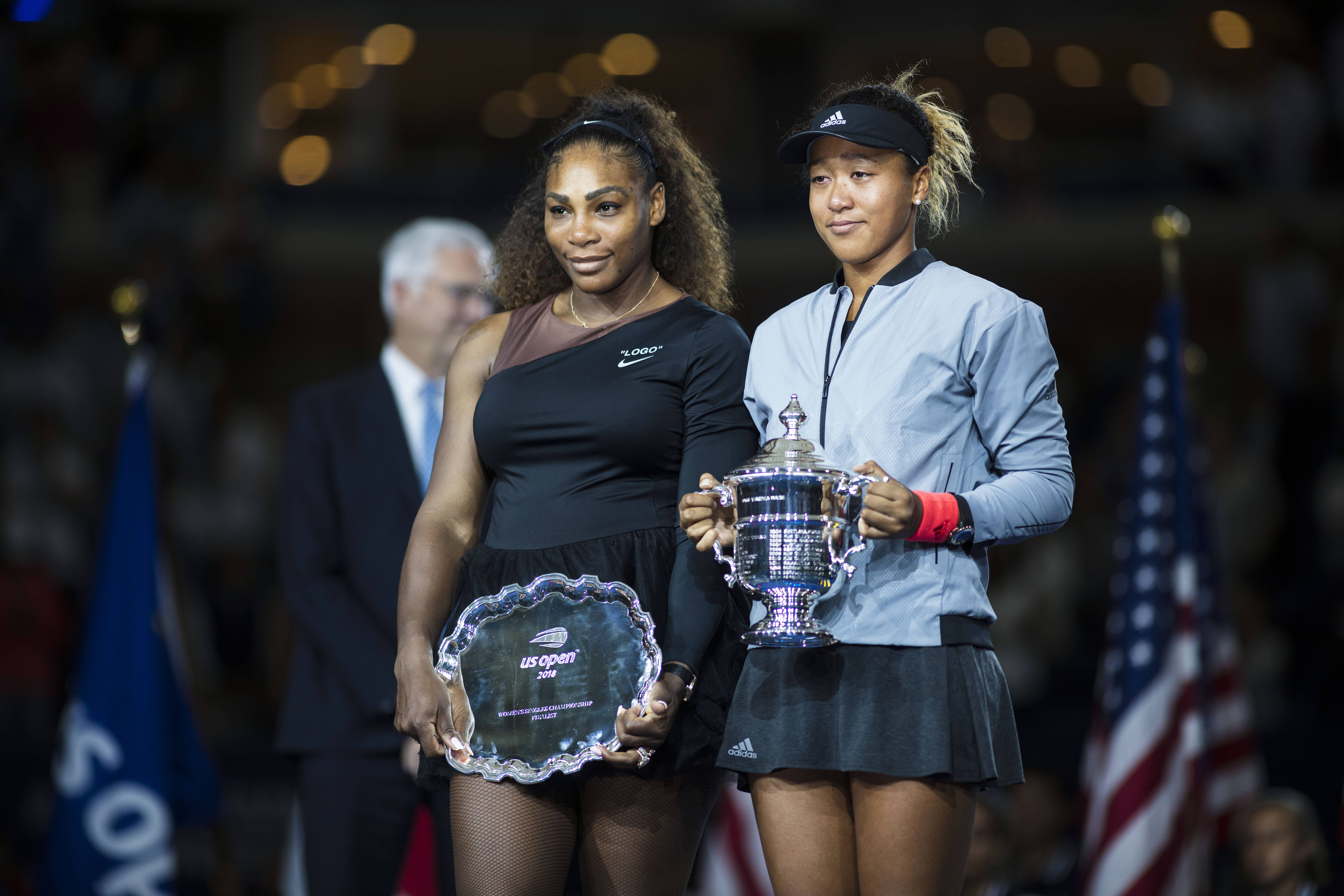 2018 US Open Tennis Tournament- Day Thirteen.  Naomi Osaka of Japan with the winners trophy and Serena Williams of the United States with the runners up trophy after the Women's Singles Final on Arthur Ashe Stadium at the 2018 US Open Tennis Tournament at the USTA Billie Jean King National Tennis Center on September 8th, 2018 in Flushing, Queens, New York City.  (Photo by Tim Clayton/Corbis via Getty Images)