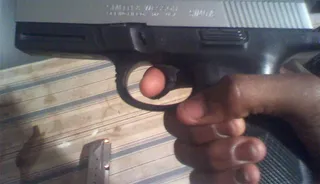 Cellphone Picture of a Gun - A person holds a gun in a photo taken from Trayvon's cell phone. (Photo: Sanford District Court)