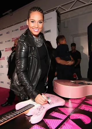 Keys on Strings - Pregnant&nbsp;Alicia Keys autographs a guitar backstage during CBS Radio's We Can Survive at the Hollywood Bowl in Los Angeles.(Photo: Christopher Polk/Getty Images for CBS Radio Inc.)