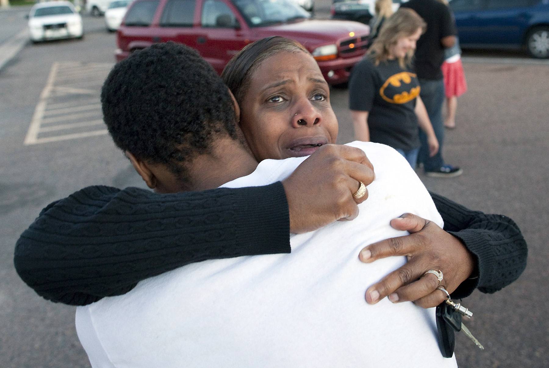 Shamecca Davis hugs her son Isaiah Bow, who was an eye witness to the shooting, outside Gateway High School where witness were brought for questioning Friday, July 20, 2012 in Denver.  After leaving the theater Bow went back in to find his girlfriend. " I didn't want to leave her in there. But she's ok now," Bow said.   A gunman wearing a gas mask set off an unknown gas and fired into a crowded movie theater at a midnight opening of the Batman movie "The Dark Knight Rises," killing at least 12 people and injuring at least 50 others, authorities said. (AP Photo/Barry Gutierrez)
