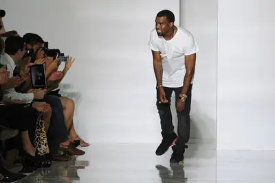 Take a Bow!&nbsp; - After the show, Kanye took a bow amid applause for the showing of his first fashion collection. The designer kept it simple in a white T-shirt, black jeans and Nike sneakers. Maybe he’ll foray into menswear next?(Photo by Pascal Le Segretain/Getty Images)&nbsp;