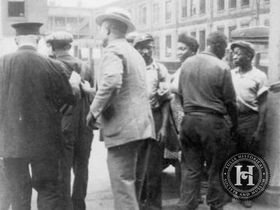 Police Violence of Yesteryear - Police gave litle assistance to Greenwood District residents during the attack as many of them joined the mob attacking the Black population. In this photo, a group of African Americans witness two white men, one a uniformed officer, detain and lead one African American man away.