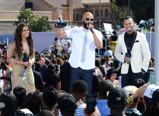 Award Tour - Common wins the Centric Award, the first trophy of the night, given to him onstage by Rocsi and Terrence J at the 2012 BET Awards Pre-Show. Common congratulated and thanked BET networks for representing African-Americans in a postive light.(Photo: Earl Gibson III/Getty Images For BET)