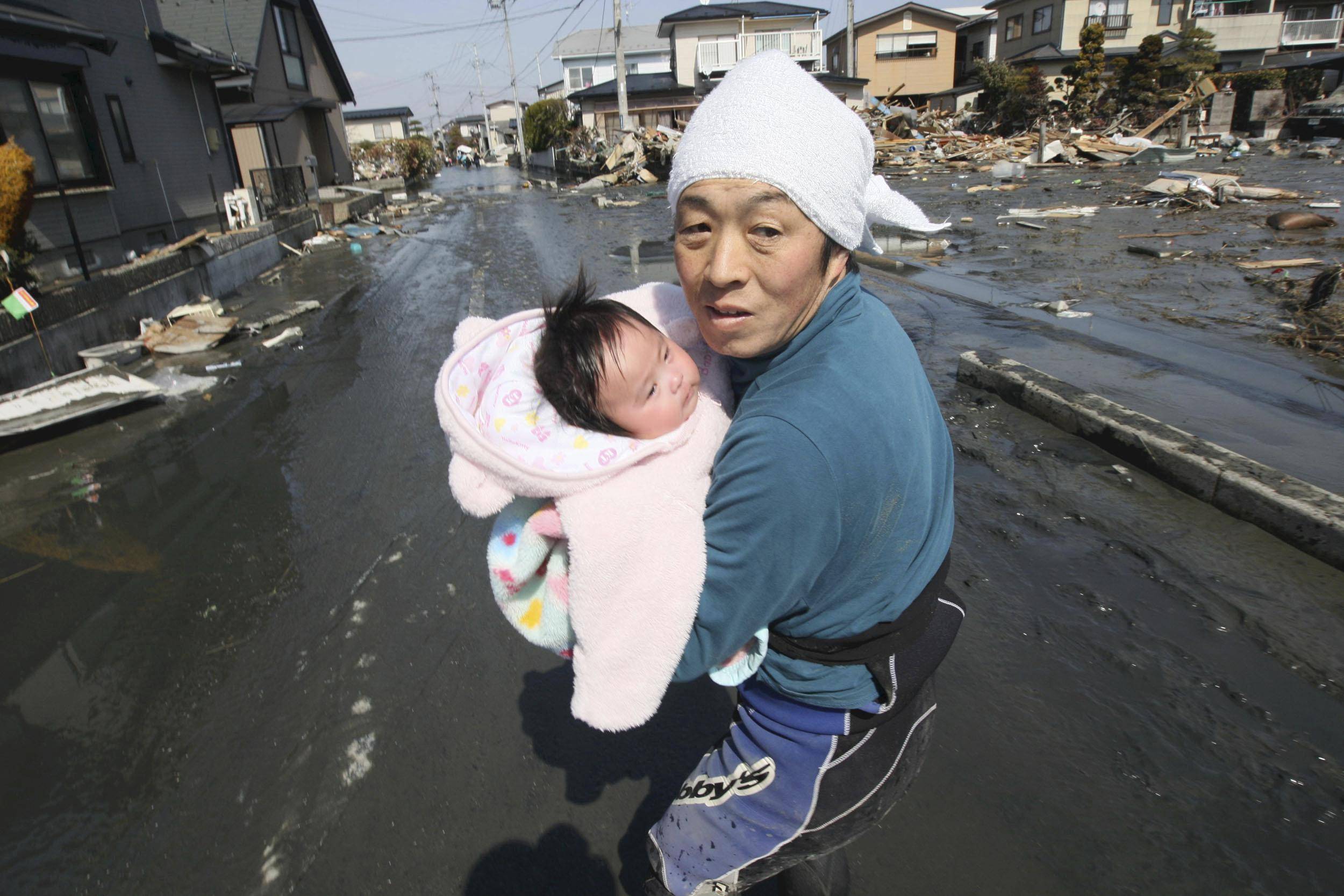 False Alarm - Japanese fears of a second tsunami proved unfounded on Monday, local media said, as the national weather agency made clear that it had not detected a wave on the Pacific coast. In this image, a father and his young daughter flee after getting word of the second tsunami warning. (Photos: AP Photo/The Yomiuri Shimbun, Hiroto Sekiguchi)