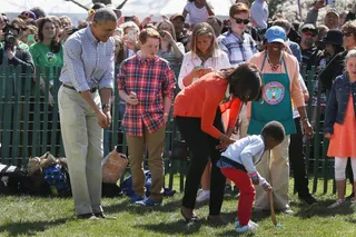 Two Helping Hands - Obama offers some tips as the first lady helps a little boy roll an Easter egg down the White House lawn.   (Photo: Mark Wilson/Getty Images)