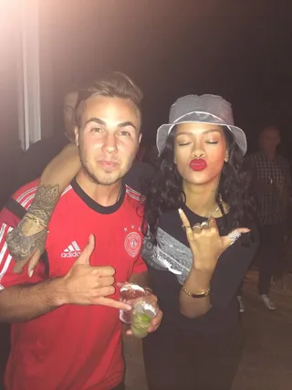 #Goals - She wore a silver Shaun Samson bucket hat to cozy up to German striker Mario Götze at the World Cup final. A red lip is the only other accessory she needs.  (Photo: Rihanna via Twitter)