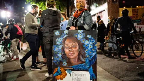 SEATTLE, WA - JUNE 07: A demonstrator holds a painting of Breonna Taylor during a protest near the Seattle Police Departments East Precinct on June 7, 2020 in Seattle, Washington. Earlier in the evening, a suspect drove into the crowd of protesters and shot one person, which happened after a day of peaceful protests across the city. (Photo by David Ryder/Getty Images)