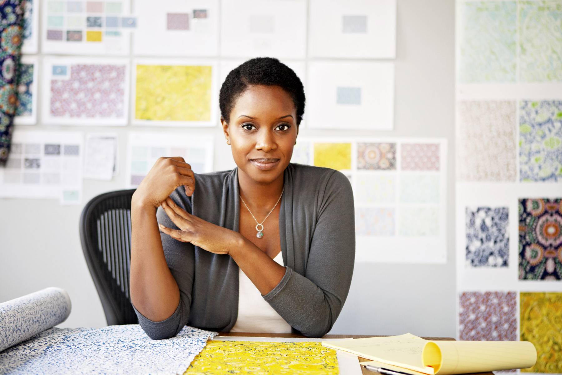 young woman looking at fabric at her desk