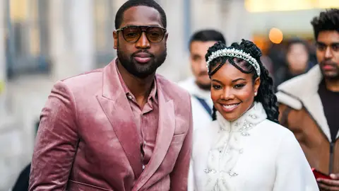 PARIS, FRANCE - JANUARY 20: Dwayne Wade (L) wears sunglasses, a pink velvet shirt, a pink velvet jacket, a matched belt  ;  Gabrielle Union (R) wears a pearl headband, a white fluffy jacket with rhinestone embroideries, a mandarin collar and bell sleeves, outside Ralph & Russo, during Paris Fashion Week - Haute Couture Spring/Summer 2020, on January 20, 2020 in Paris, France. (Photo by Edward Berthelot/Getty Images )