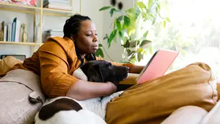 Woman sitting reading with her dog. 