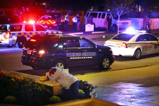 Overwhelming Pain - A man in the picture kneels across from the sight where a shooter opened fire on innocent congregants Wednesday.(Photo: Wade Spees/The Post And Courier via AP)