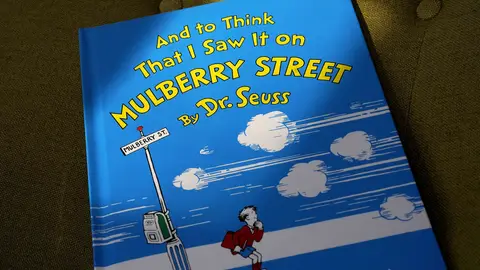A copy of the book "And to Think That I Saw It on Mulberry Street," by Dr. Seuss, rests in a chair, Monday, March 1, 2021, in Walpole, Mass. Dr. Seuss Enterprises, the business that preserves and protects the author and illustrator's legacy, announced on his birthday, Tuesday, March 2, 2021, that it would cease publication of several children's titles including "And to Think That I Saw It on Mulberry Street" and "If I Ran the Zoo," because of insensitive and racist imagery. (AP Photo/Steven Senne)