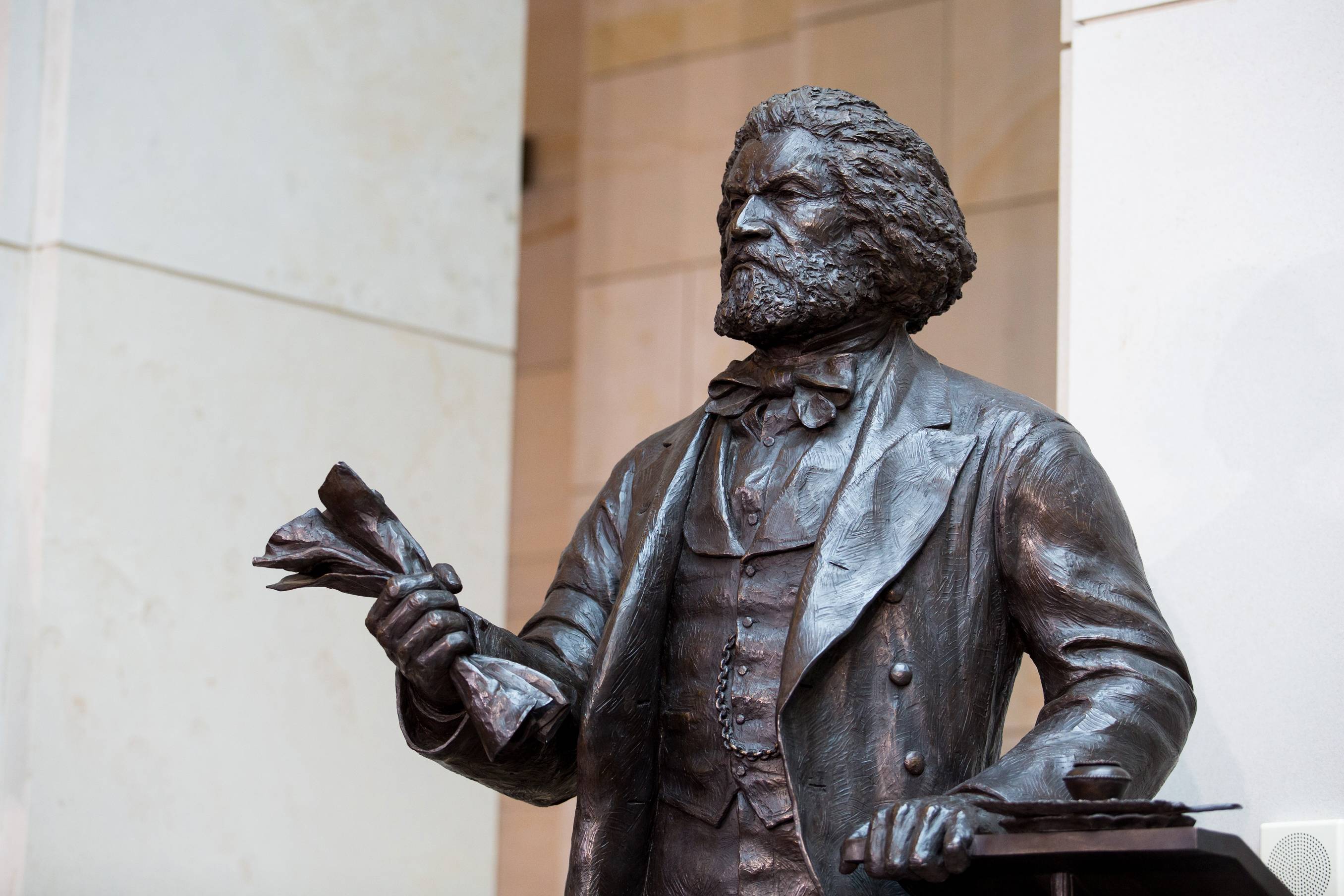 Frederick Douglass Honored With Capitol Statue  - A ceremony was held to unveil a statue honoring abolitionist Frederick Douglass in the Capitol Visitor’s Center Emancipation Hall. After years of delay, the over seven-feet-tall bronze figure became the first statue to represent the District of Columbia in the Emancipation Hall.&nbsp;(Photo: Drew Angerer/Getty Images)