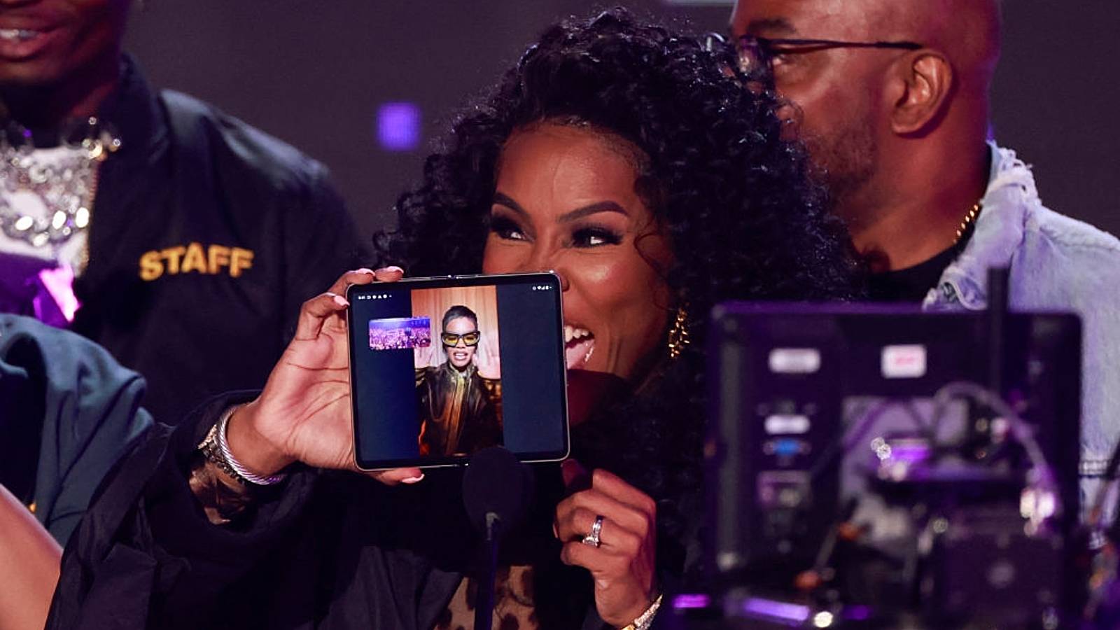 Winner of Best Video Director of the Year Teyana "Spike Tey" Taylor is seen on a smartphone screen held by her mom on stage during the 2023 BET awards at the Microsoft theatre in Los Angeles, June 25, 2023.  