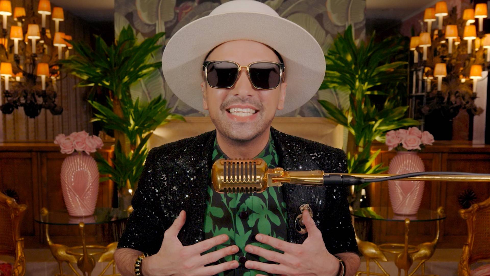 DJ Cassidy wearing a black jacket, black and green shirt, and a white hat while hosting DJ Cassidy's Pass the Mic: 2021 BET Soul Train Edition.