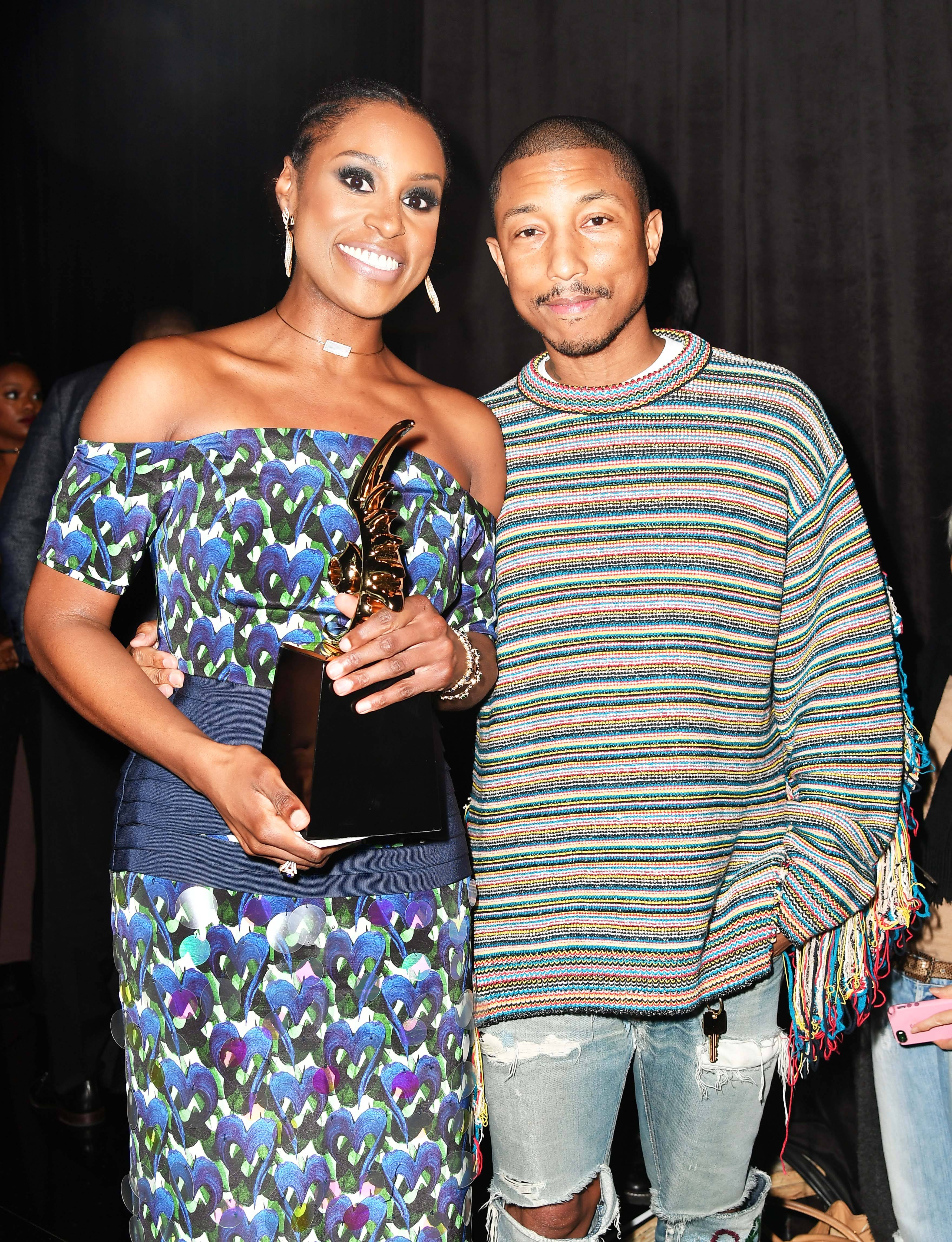 Not So Awkward Acceptance - Rising Star honoree Issa Rae and producer/music artist Pharrell Williams pose together after she accepts her win. (Photo: Earl Gibson III/Getty Images for BET)&nbsp;