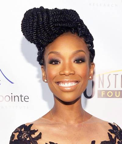 Brandy - The star pulls her fresh Senegalese twists into a dramatic side bun, pairing her statement hair with full brows, frosted lips and warm blush. By Metanoya Z. Webb  (Photo: John M. Heller/Getty Images)