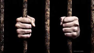 Hands holding jail cell bars on BET Breaks in 2018.