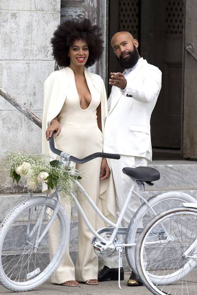 Love Story - Solange Knowles and Alan Ferguson&nbsp;are the perfect match as they arrive at their New Orleans wedding on white bicycles. The bride wore a Stéphane Roland backless jumpsuit, while the groom rocked a suit with black gold-tipped oxfords. We wish them a happily ever after!(Photo: INFphoto.com)&nbsp;