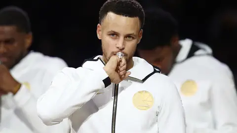 OAKLAND, CA - OCTOBER 16: Stephen Curry #30 of the Golden State Warriors kisses at his 2017-2018 Championship ring prior to their game against the Oklahoma City Thunder at ORACLE Arena on October 16, 2018 in Oakland, California. NOTE TO USER: User expressly acknowledges and agrees that, by downloading and or using this photograph, User is consenting to the terms and conditions of the Getty Images License Agreement. (Photo by Ezra Shaw/Getty Images)