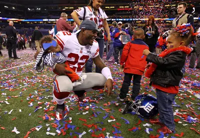 The Kids Like Confetti - Giants defensive back Derrick Martin enjoys a family moment after doing battle on the field. (Photo: Al Bello/Getty Images)