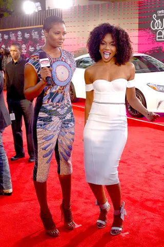 Ready for the Spotlight - Eva Marcille chops it up with fellow actress Wendy Raquel Robinson. Robinson styles her off-the-shoulder white frock with a pop of magenta lipstick and stunning ankle-strap sandals.  (Photo: Bryan Steffy/BET/Getty Images)