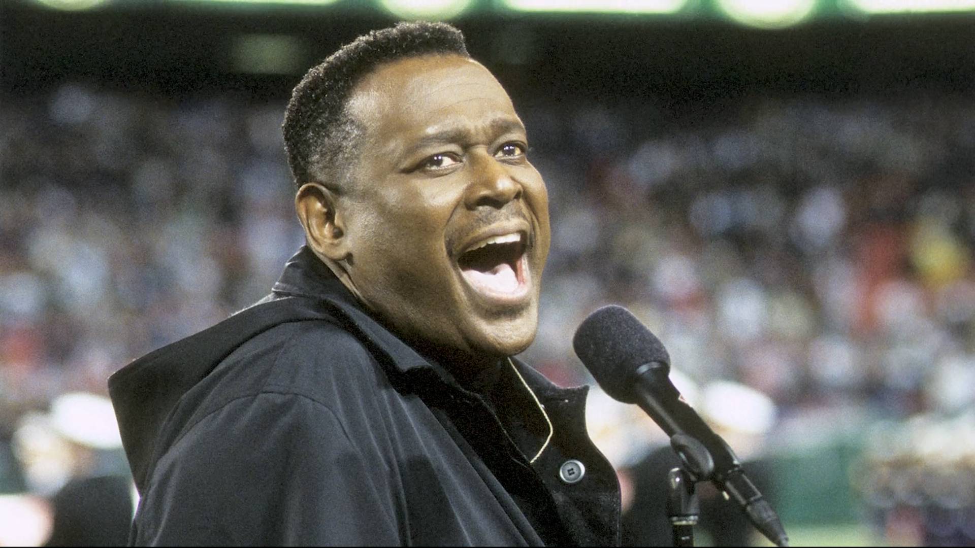 Luther Vandross singing in a black jacket.
