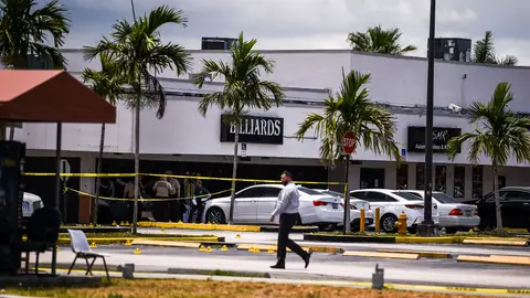 Miami Dade police officers collect evidence from the parking lot in front of Billiard's club that was rented for a concert, after three gunmen killed two people and injured 20 overnight in the Hialeah area of Miami Dade county on May 30 2021. - Two people were killed and at least 20 injured Sunday when three shooters fired indiscriminately into a crowd outside a concert in Miami, Florida, local police said. Gunfire erupted during the early hours outside a billiards hall in a row of businesses near Miami Gardens, northwest of the coastal city's downtown. People crowded the venue, which was "hosting a scheduled event and several patrons were standing outside," Miami-Dade Police Department said in a statement. (Photo by CHANDAN KHANNA / AFP) (Photo by CHANDAN KHANNA/AFP via Getty Images)