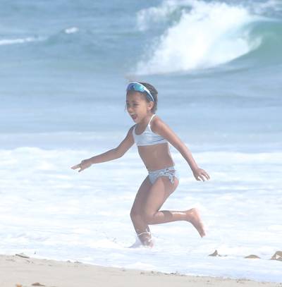 Fun In The Sun - While mom and dad were in Paris, North West was enjoying the first day of summer and looking adorable in her metallic blue swimsuit paired with matching sunnies. (Photo: X17)