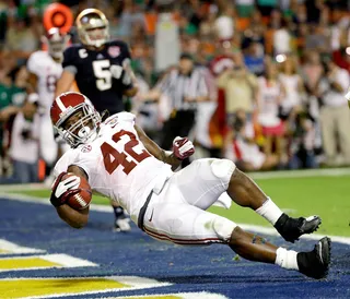Just Slide - Alabama's Eddie Lacy lands safely in the end zone during the first half. The running back rushed for 140 yards and scored two touchdowns during the game. (Photo: David J. Phillip/AP Photo)