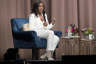 Angelic Slay! - Michelle Obama made her way to Brooklyn for the New York City stop of her Becoming book tour. Our forever first lady looked stunning in a custom all-white satin twill tuxedo from&nbsp;Brandon Maxwell's SS 2019 collection and slayed the look with a pair of white Jimmy Choo caged booties&nbsp;($1,050).&nbsp;(Photo:&nbsp;Mary Altaffer/AP/Shutterstock)
