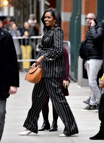 Power Player&nbsp; - Michelle Obama was seen leaving Barnes and Nobles book store in NYC for after signing copies of her bestselling book, Becoming. Our former first lady looks like a boss in a black-and-white pinstriped suit that featured a tie-waist jacket and wide-leg trousers. She added a splash of color with a cognac leather Chloé bag and a pair of white pointy-toe pumps by Mansur Gavriel ($545).(Photo: Erik Pendzich/Shutterstock)