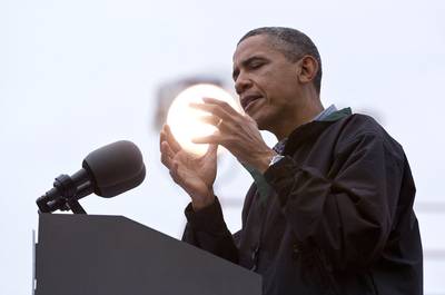 The World in His Hands - A light shines behind Obama as he speaks at an August campaign event at Bayliss Park in Council Bluffs, Iowa, during a three-day campaign bus tour through the state.   (Photo: AP Photo/Carolyn Kaster)