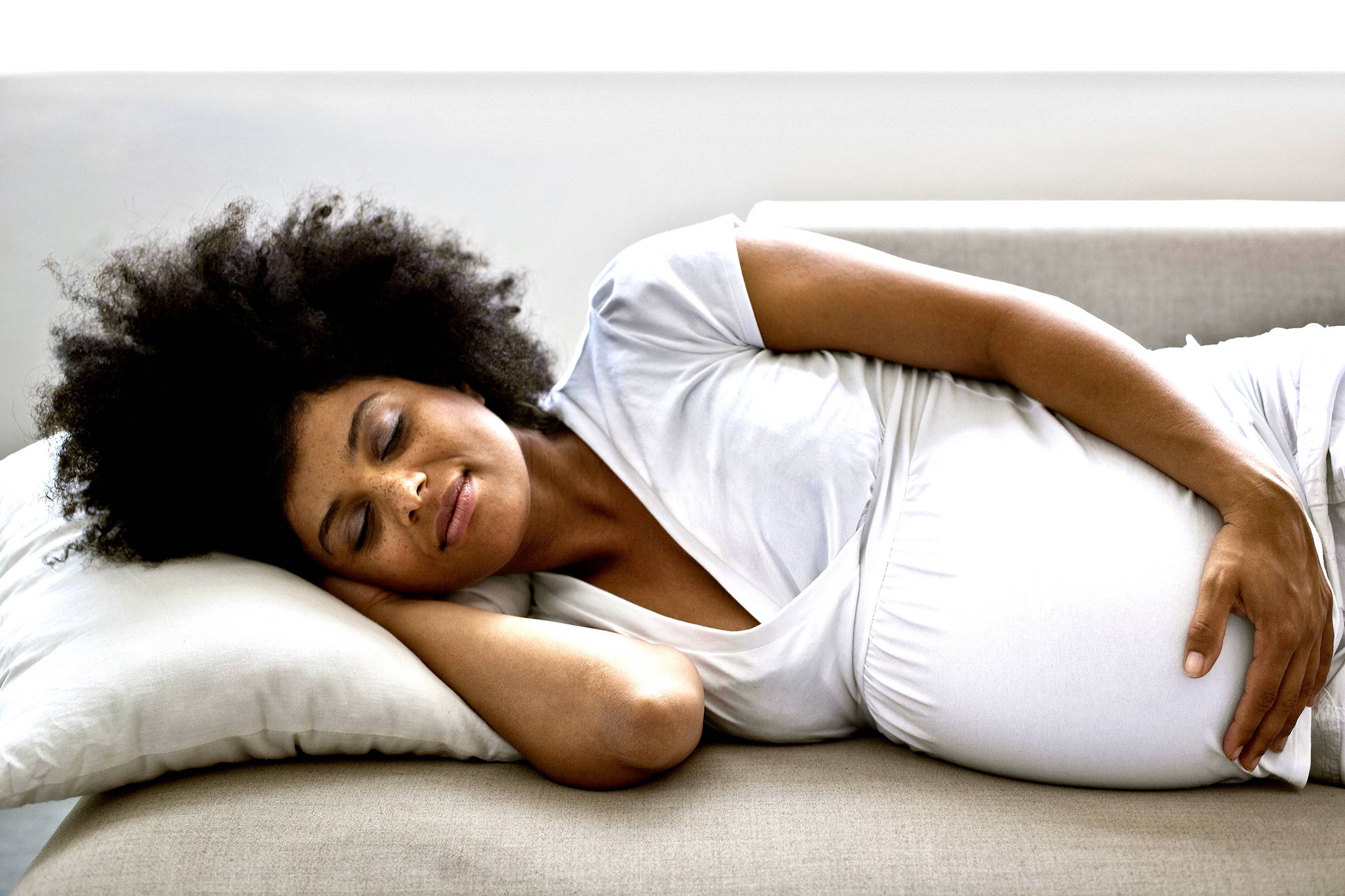 pregnant woman lying down on a couch