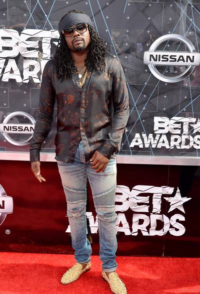 Wale&nbsp; - The rapper clearly isn’t afraid to stand out. Case in point, check out his quirky button-down shirt with bronze watercolor effect, distressed light-wash denim, and spiked gold smoking slippers.   (Photo: Earl Gibson/BET/Getty Images for BET)