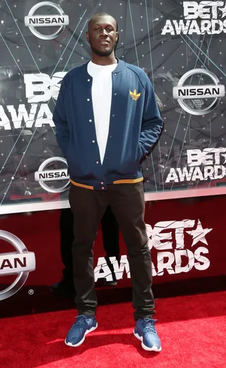 Stormzy - The British recording artist schools us on how to make a navy blue and blue work together. He meshes the hues together to make one stylish ‘fit. Guys, you better go cop an Adidas varsity ASAP!&nbsp; (Photo: Frederick M. Brown/Getty Images for BET)