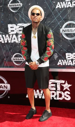 Chris Brown - Before taking the stage, Breezy&nbsp;brings his eclectic style to the red carpet: a rose-print leather jacket worn over a plain white T-shirt, black shorts, leather sneaks and a white fedora. (Photo: Frederick M. Brown/Getty Images for BET)