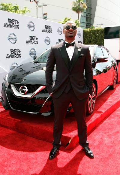 Big Tigger - Who doesn’t love a sharp black suit? The radio/TV host adds stunna shades and patent loafers for the perfect finish.  (Photo: Maury Phillips/BET/Getty Images for BET)