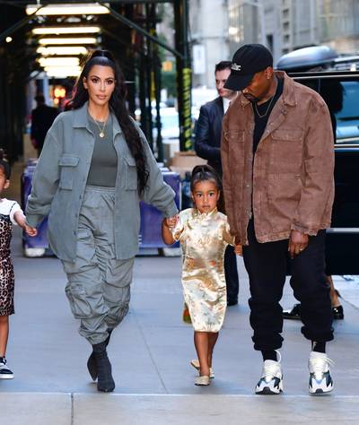 North West Cool Like Kim K &amp; Daddy Ye - North West was looking cute as ever while exploring NYC with her parents for her birthday. She was rocking a traditional-looking, gold cheongasm dress as well as gold Chinese slippers. (Photo: James Devaney/GC Images)