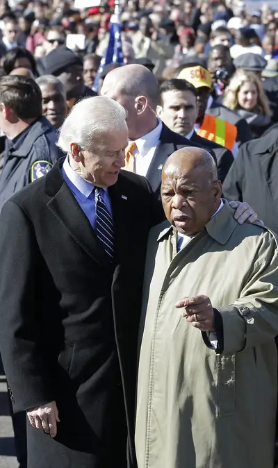 Reflection - Biden and Lewis share a moment and an embrace before leading the group of thousands across the Edmund Pettus Bridge where the congressman was once beaten in 1965.  (Photo: AP Photo/Dave Martin)